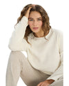 Woman wearing a white long-sleeve top and beige pants