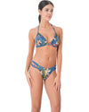 Model wearing a blue triangle bikini with multicolor tropical floral print and mid-rise bottoms