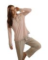 Woman wearing pink long-sleeve pajama top with grey trim and grey pants