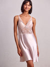 model wearing V-neck satin babydoll dress with intricate embroidery on the front and back.