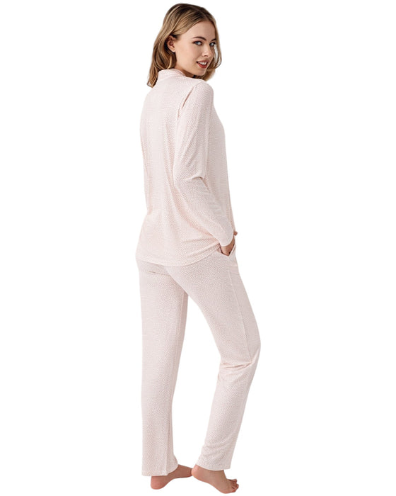 Woman wearing a light pink pajama set with mini dots