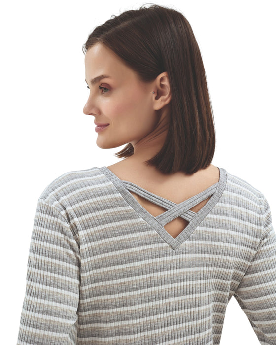 Woman wearing a gray and white striped long-sleeve top with criss-cross back design