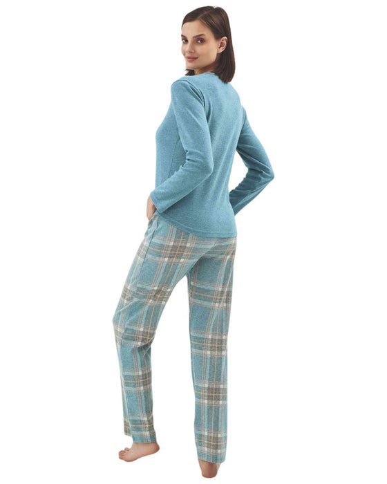 Woman wearing a blue long-sleeve top with a star design and plaid pants 