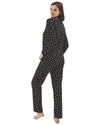 Woman wearing a black pajama set with pink heart pattern