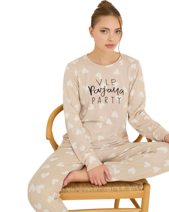 Woman wearing a beige pajama set with heart patterns and text