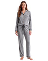 A woman modeling a two-piece gray heather pajama set with black piping and brown buttons