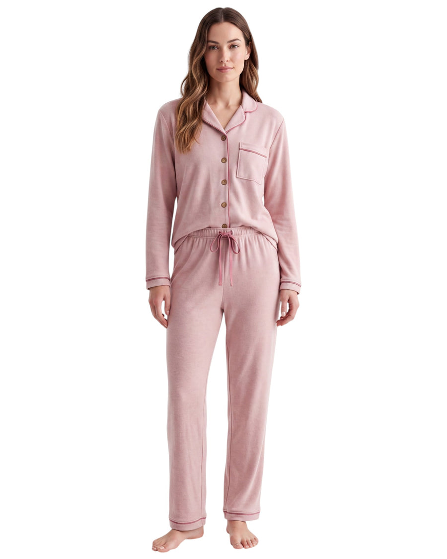 A woman modeling a two-piece long-sleeve pajama set in dusty pink, featuring a button-front top with a chest pocket and matching drawstring pants