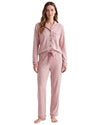 A woman modeling a two-piece long-sleeve pajama set in dusty pink, featuring a button-front top with a chest pocket and matching drawstring pants