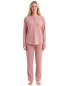 A woman modeling a two-piece dusty rose pajama set consisting of a long-sleeve henley top with three buttons and matching sweatpants