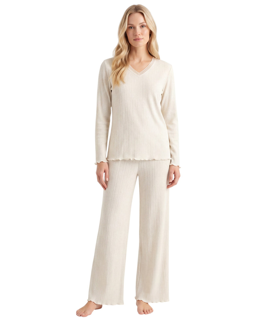 A woman modeling a matching two-piece loungewear set consisting of a long-sleeve V-neck top and wide-leg pants in a cream ribbed knit fabric