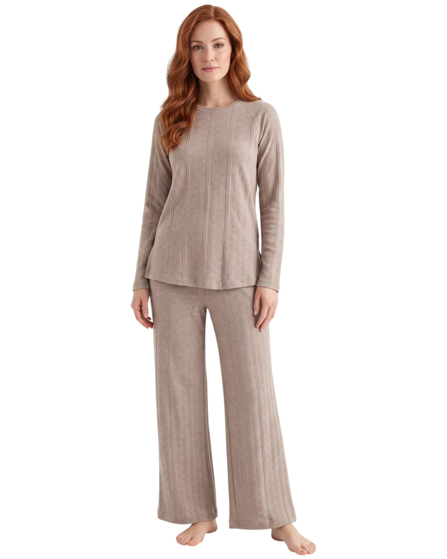 A woman modeling a matching two-piece knit loungewear set in a light taupe-beige color, featuring a long-sleeve top and wide-leg pants