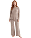 A woman modeling a matching two-piece knit loungewear set in a light taupe-beige color, featuring a long-sleeve top and wide-leg pants