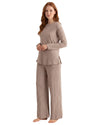 A woman modeling a two-piece ribbed knit loungewear set in a warm taupe-beige color, featuring a long-sleeve top and matching wide-leg pants