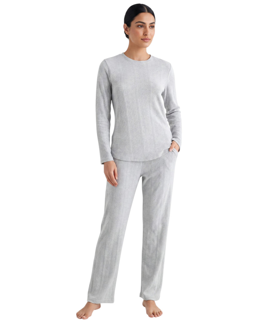 A woman modeling a light gray two-piece loungewear set consisting of a long-sleeve crewneck top and matching straight-leg pants