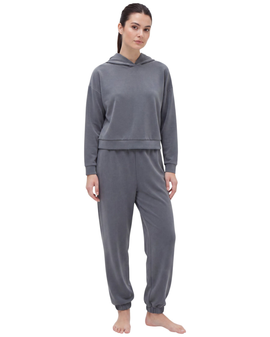 A woman modeling a matching gray two-piece loungewear set consisting of a cropped long-sleeve hoodie and jogger pants