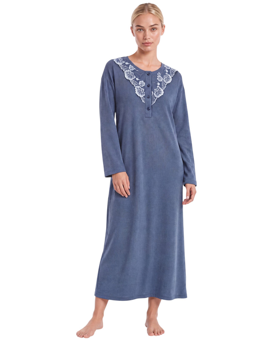 A woman modeling a long-sleeve blue nightgown with white floral lace trim along the V-neckline
