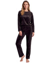A woman modeling a two-piece black velvet pajama set with a long-sleeve top featuring the word 'SIMPLY' printed in white on the chest, and matching drawstring pants