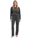 A woman modeling a dark gray two-piece velour pajama set with a long-sleeve top featuring 'be mine' script embroidery and matching pants