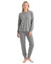 A woman modeling a two-piece gray loungewear set consisting of a long-sleeve crewneck top and matching jogger pants