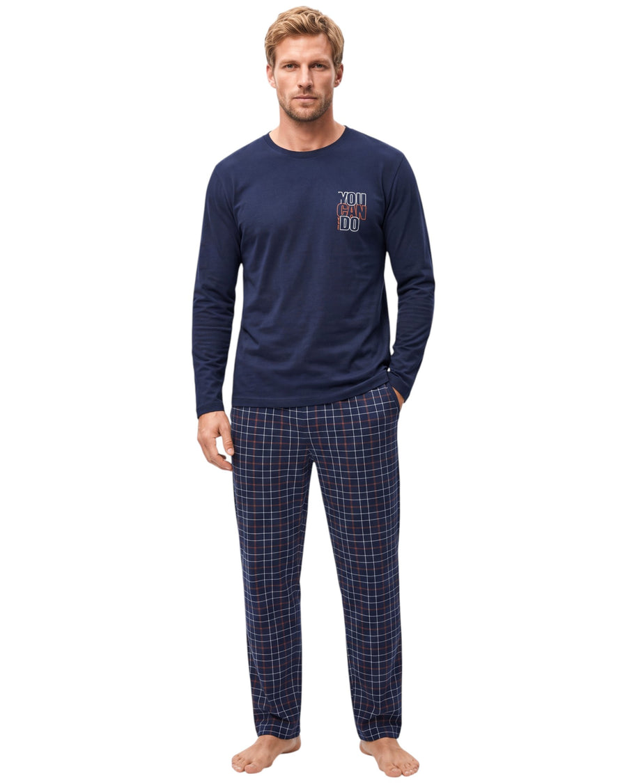 Man wearing a navy blue long-sleeve pajama top with a "You Can Do" chest print and matching navy checkered long pants