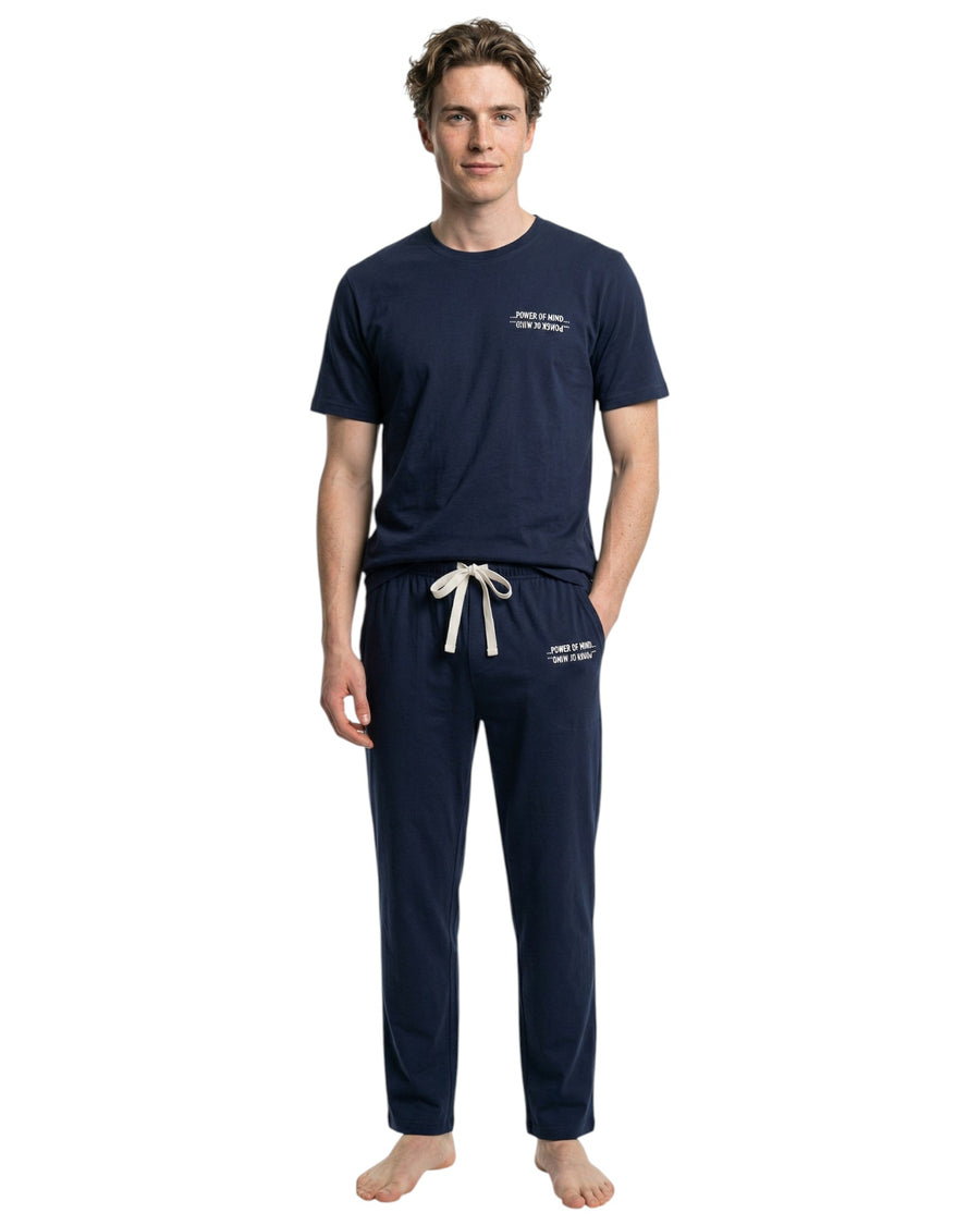 Man wearing navy blue pajama set with white text 
