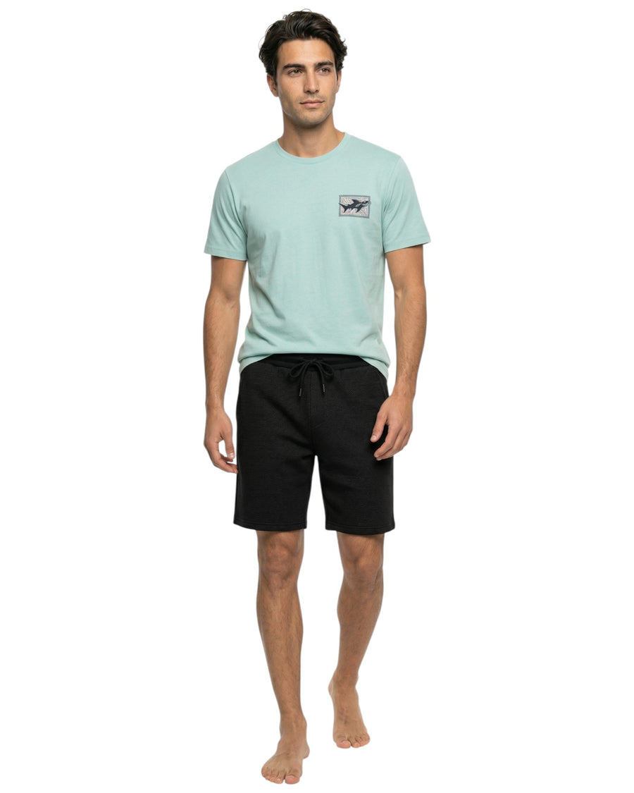 Man wearing aqua t-shirt and black shorts 
