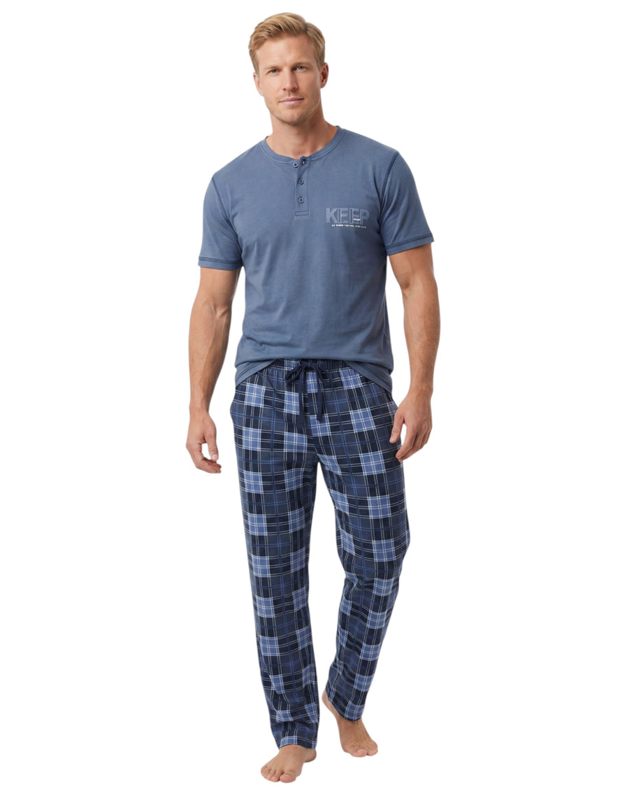 Man wearing a blue henley shirt and plaid pants 
