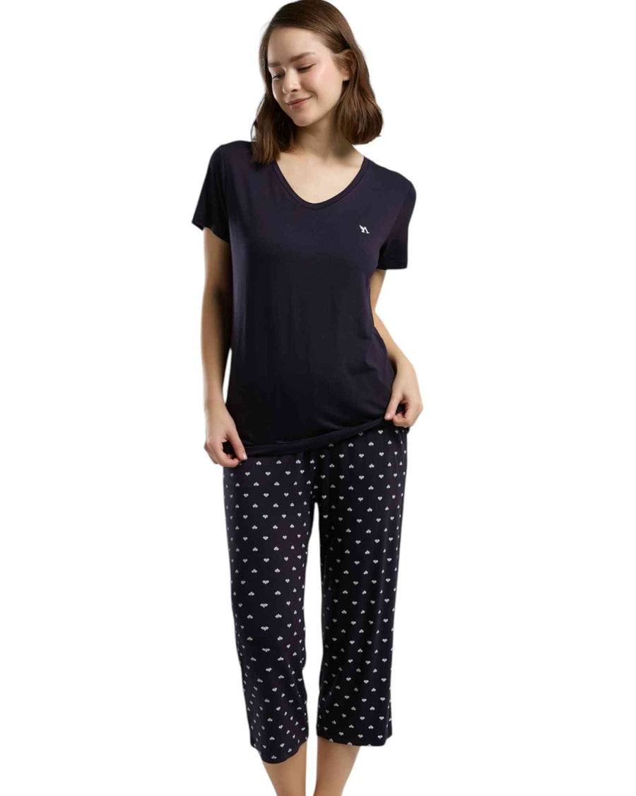 Woman wearing a navy blue top and polka dot capri pants 