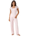 A woman modeling a light pink two-piece pajama set with a lace-trimmed short-sleeve top and matching pants