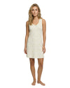 Woman wearing a cream sleeveless dress with small lemon patterns 