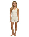 Woman wearing a cream-colored sleeveless top and shorts setwith lemon print