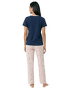Person wearing a navy blue t-shirt and light pink pajama pants with a subtle pattern 