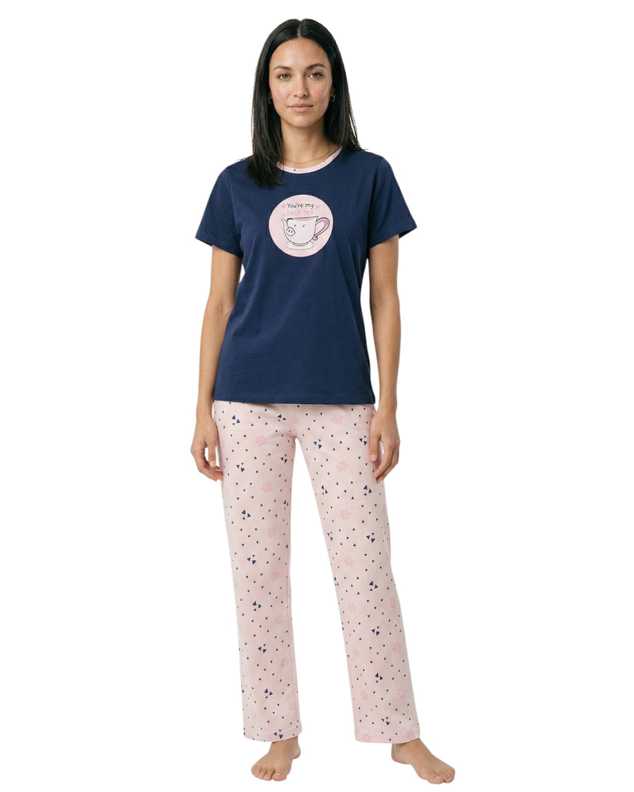 Woman wearing a navy blue t-shirt with a pink graphic and light pink pajama pants