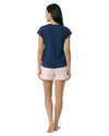Woman wearing a navy blue top and light pink shorts with a subtle pattern 