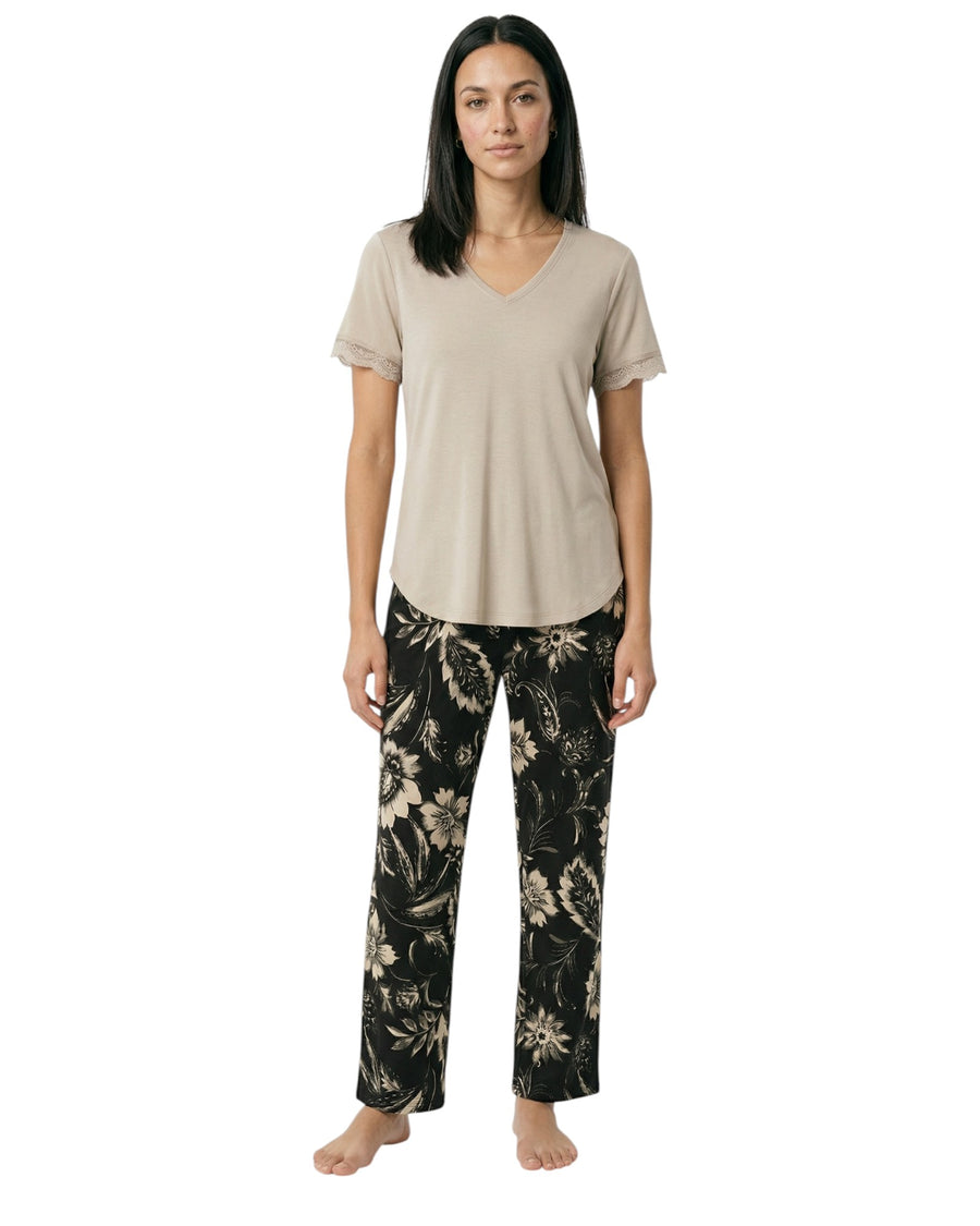 Woman wearing a beige t-shirt and black floral pants 