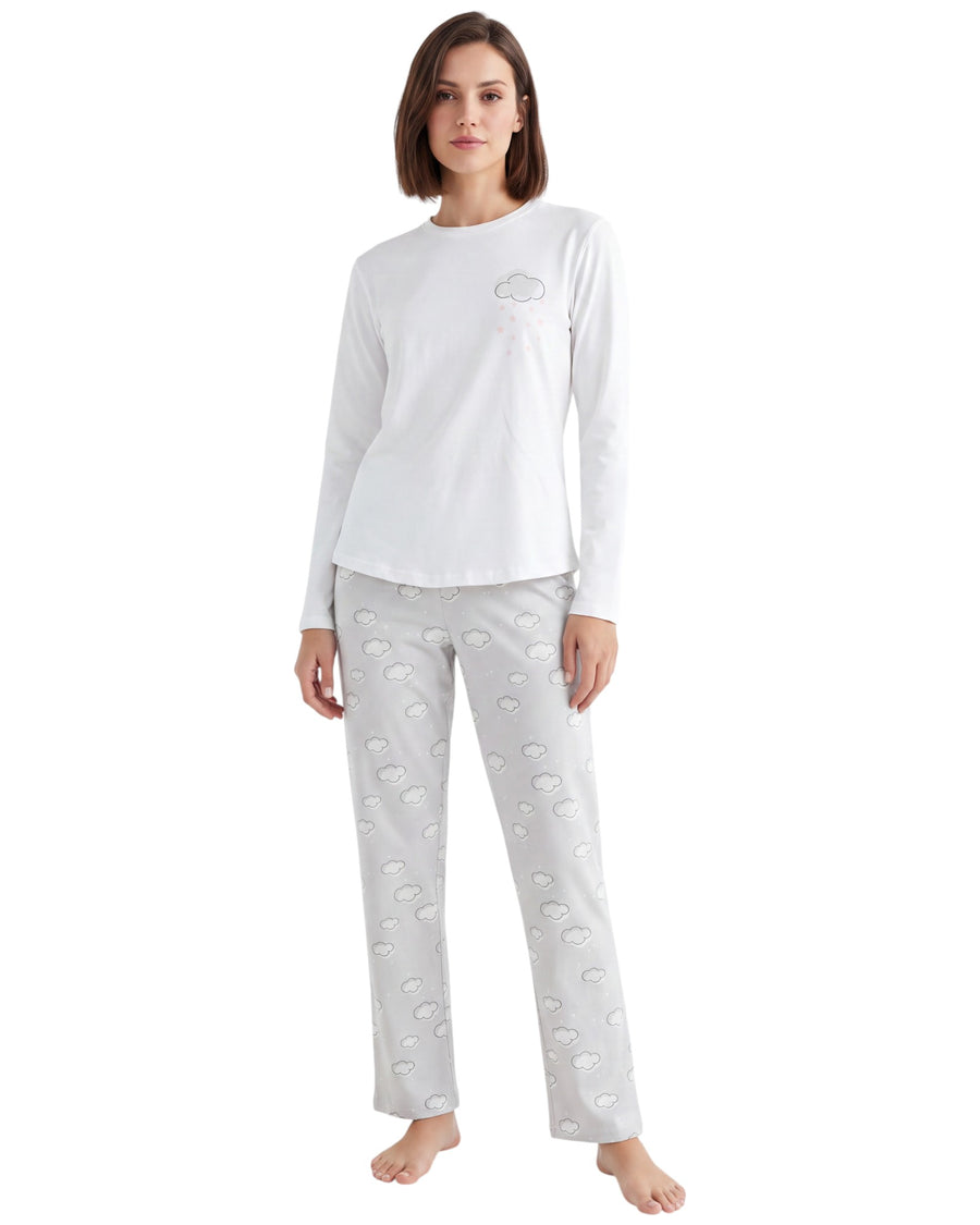 A woman modeling a two-piece pajama set consisting of a white long-sleeve top with a small cloud graphic on the chest and light gray patterned pants.