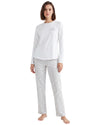 A woman modeling a two-piece pajama set consisting of a white long-sleeve top with a small cloud graphic on the chest and light gray patterned pants.