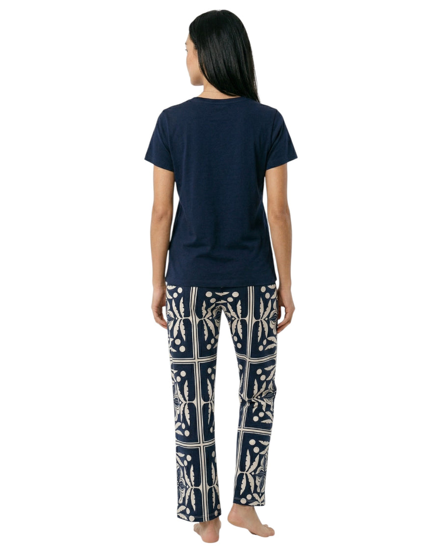 Woman wearing a navy blue t-shirt and patterned pants 
