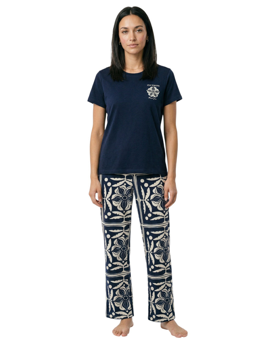 Woman wearing a navy t-shirt and patterned pants