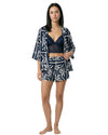 Woman wearing a navy lace bralette with printed lounge shorts and matching kimono in a navy and ivory geometric floral print.