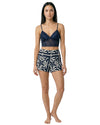 Woman wearing a navy lace bralette with printed lounge shorts 