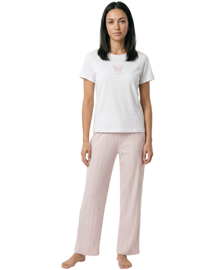 Woman wearing a white t-shirt with butterfly print and pink striped pants