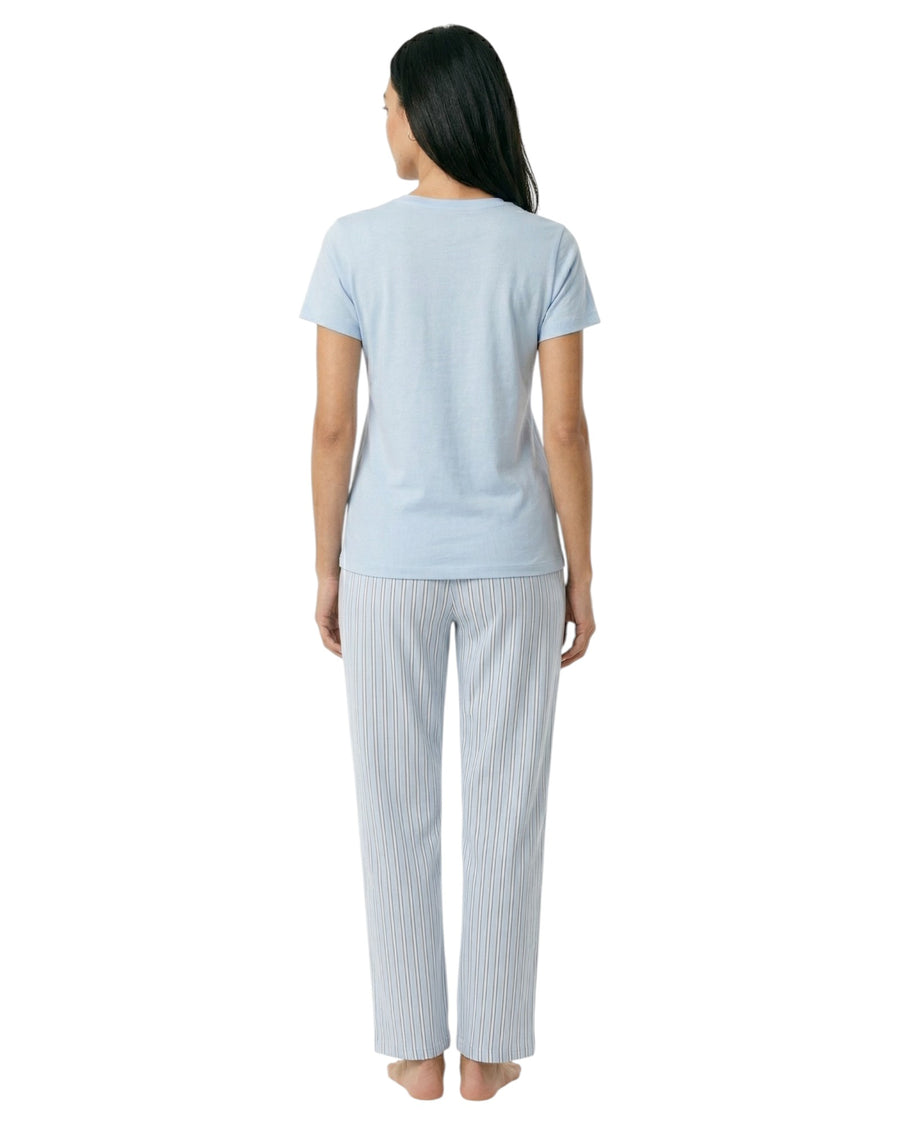 Woman wearing a light blue t-shirt and white pants with thin blue stripes 