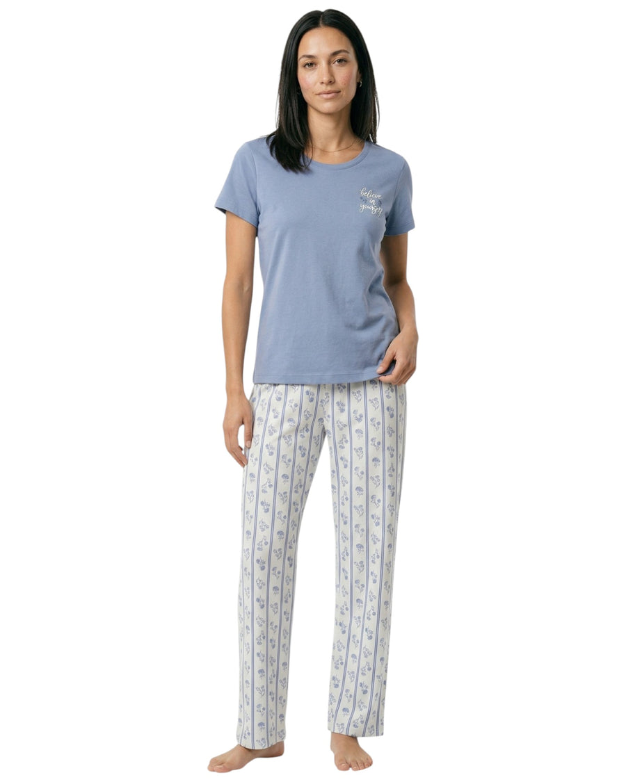 Woman wearing a blue t-shirt and patterned pajama pants 