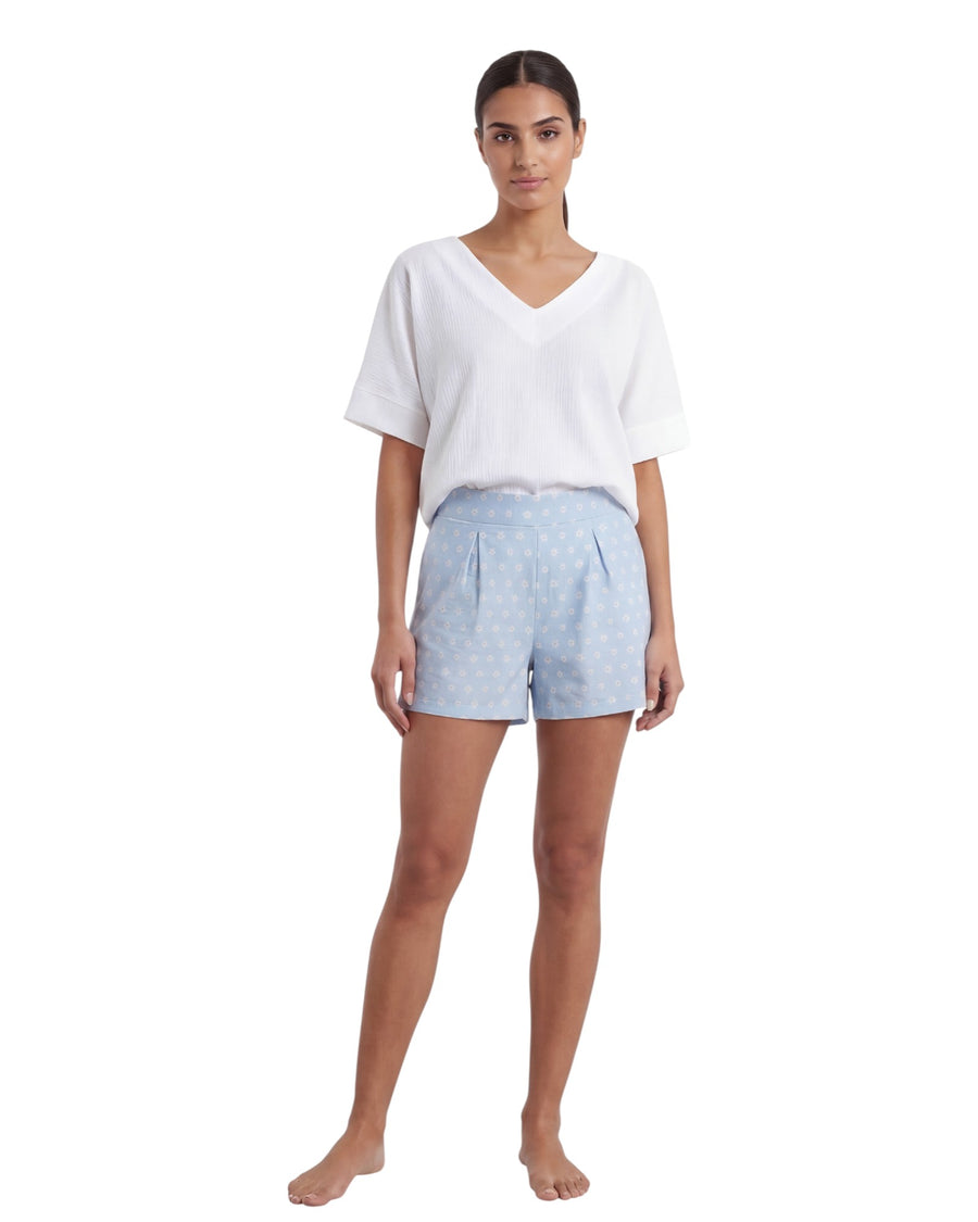 Woman wearing a white top and light blue shorts