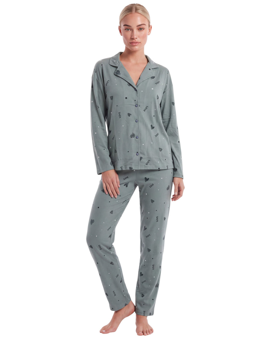 A woman modeling a two-piece pajama set consisting of a long-sleeve button-front top and matching pants in a muted sage green color with a small scattered abstract print
