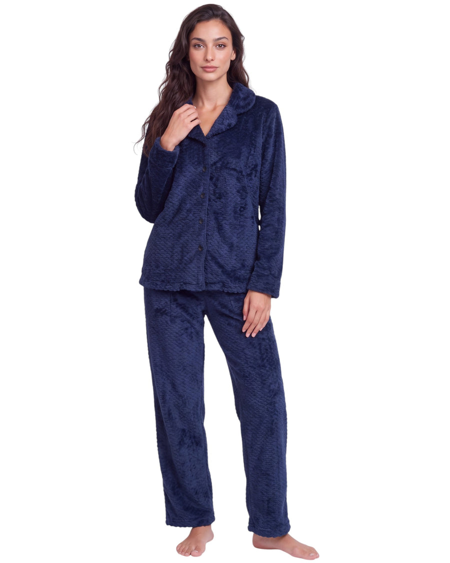 Woman wearing a navy blue plush textured long pajama set with a button-front top, classic collar, long sleeves, and matching straight-leg pants.