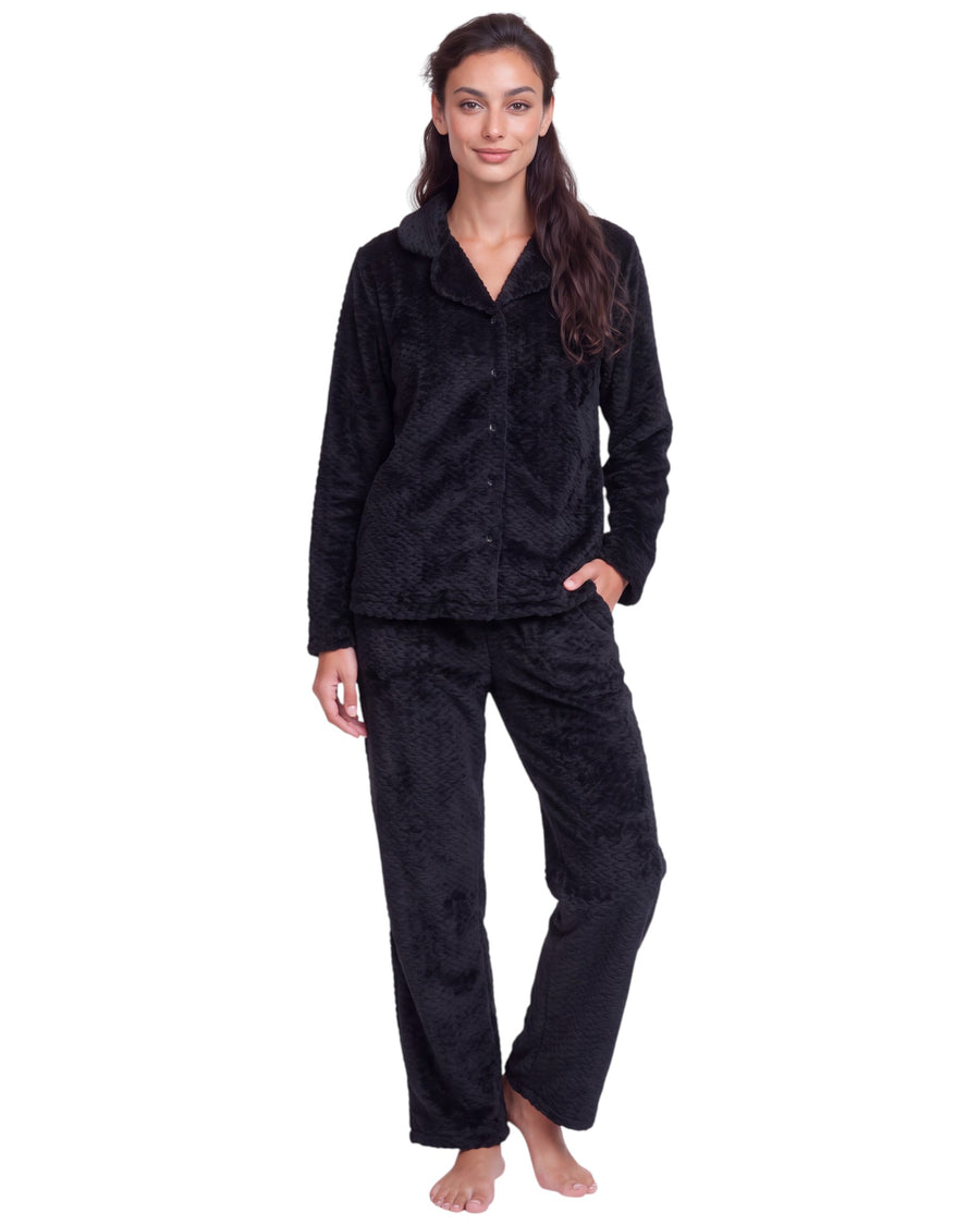 Woman wearing a black plush textured long pajama set with a button-front top, classic collar, long sleeves, and matching straight-leg pants.