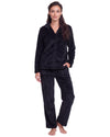 Woman wearing a black plush textured long pajama set with a button-front top, classic collar, long sleeves, and matching straight-leg pants.