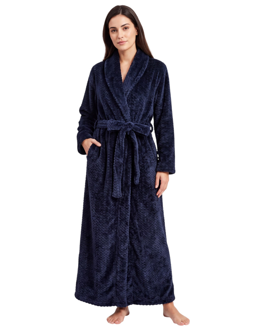Woman wearing a textured plush long robe featuring long sleeves, a shawl collar, side pockets, and an adjustable waist belt.